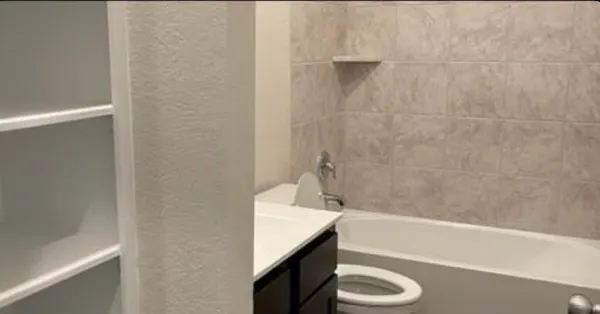 a bathroom with a granite countertop sink toilet and bathtub