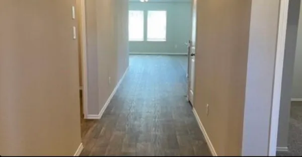 a view of a hallway with wooden floor and stairs