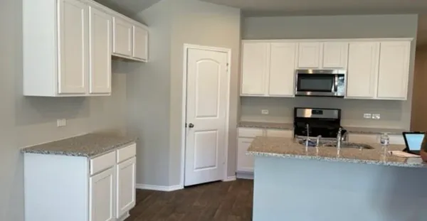 a kitchen with stainless steel appliances granite countertop a refrigerator and a stove top oven