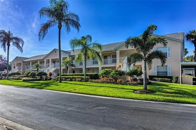 a front view of a house with a yard and potted plants