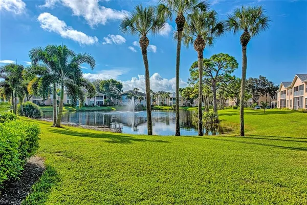 a view of swimming pool with a garden and palm trees