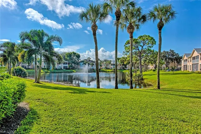 a view of swimming pool with a garden and palm trees