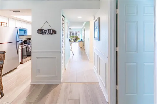 a view of a hallway with wooden floor and furniture