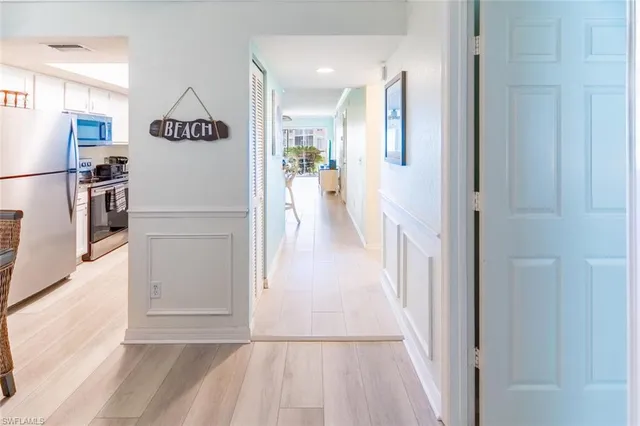 a view of a hallway with wooden floor and furniture