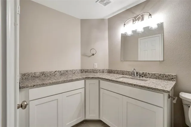 a bathroom with a granite countertop sink a large mirror and a