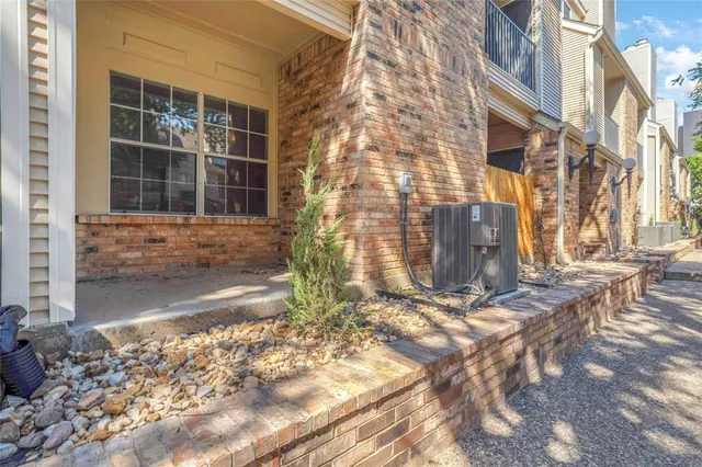 a view of a brick house with a large tree