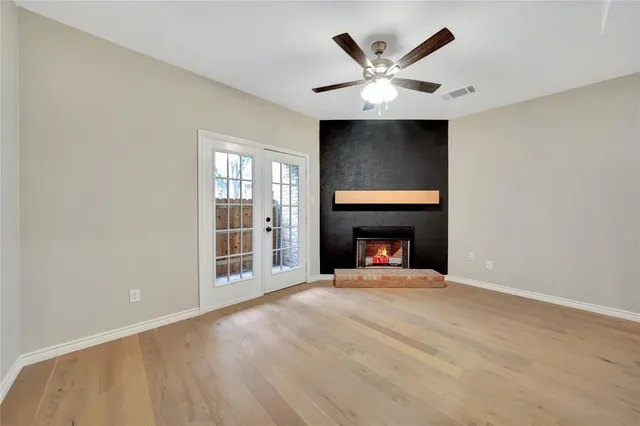 a view of an empty room with a fireplace and a window