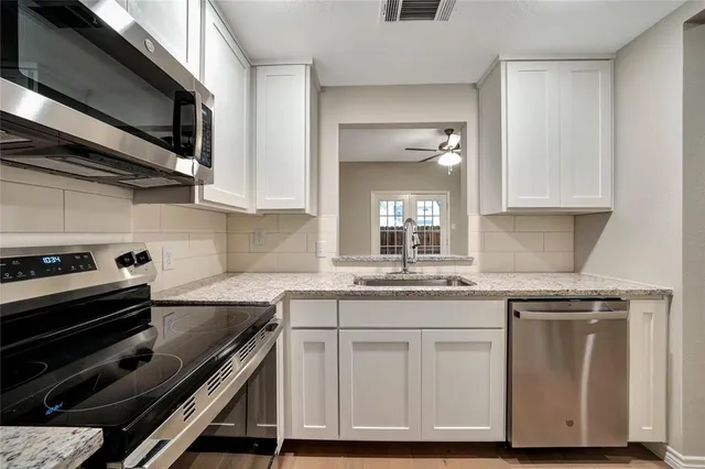 a kitchen with granite countertop a stove and a sink