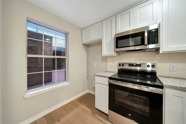 a kitchen with white cabinets and stainless steel appliances