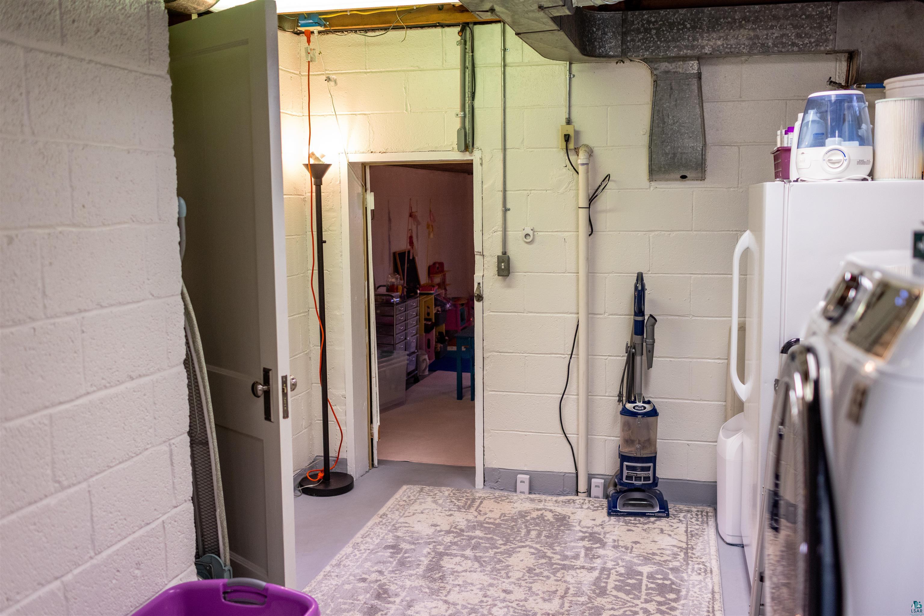 3704 Greysolon Road Duluth, MN 55804 - Photo 35 of 51 Finished basement space featuring painted block walls, a doorway to an additional room, and exposed overhead ductwork