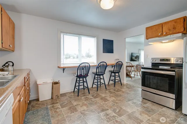 a view of a kitchen with dining area a sink and a dishwasher
