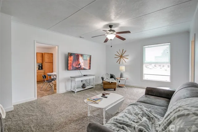 a living room with furniture a window and a flat screen tv