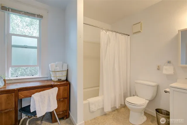 a bathroom with a toilet a sink and a window