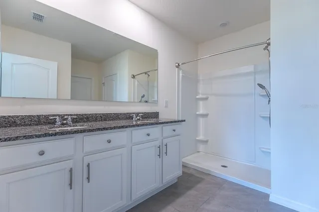 a bathroom with a granite countertop sink a toilet and shower