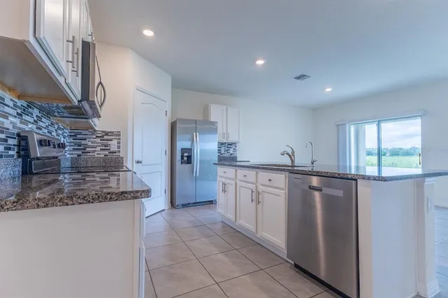 a kitchen with stainless steel appliances granite countertop a refrigerator and a sink