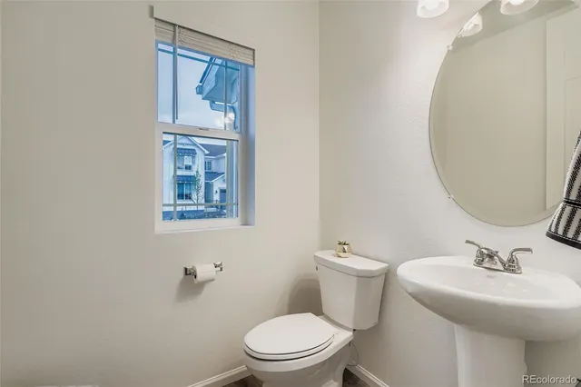 a bathroom with a toilet a sink and mirror