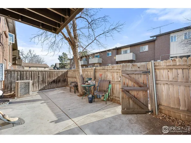 a bedroom with a bed a flat screen tv and dresser next to a window