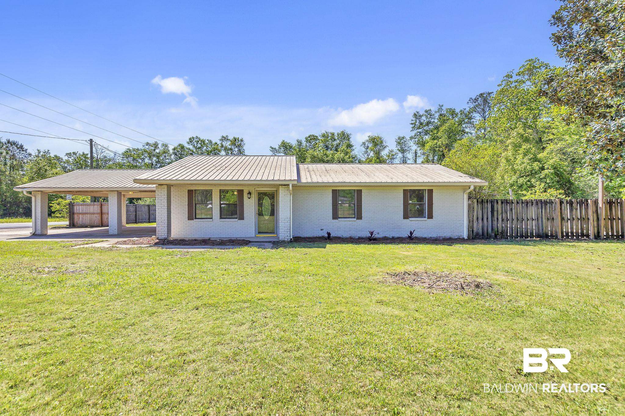 11964 Stroh Road Daphne, AL 36527 - Photo 1 of 58 Single story home with an attached carport, a front yard, metal roof, and fence