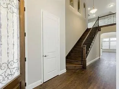 a view of a hallway with entryway wooden floor and front door