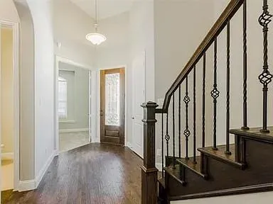 a view of a hallway with wooden floor and staircase