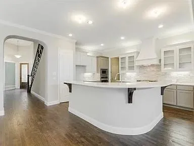 a kitchen with stainless steel appliances granite countertop a sink a stove and a wooden floors