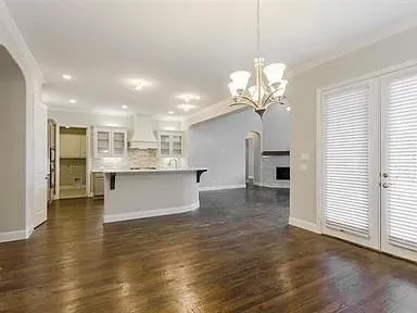 a view of a kitchen with kitchen island a chandelier and wooden floor