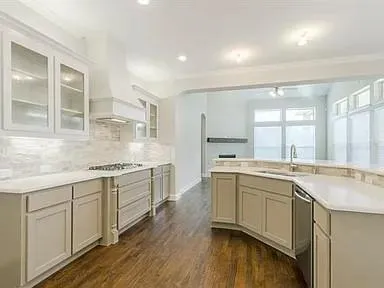 a large kitchen with a sink and cabinets