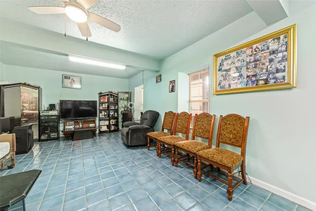 a living room with furniture a flat screen tv and kitchen view