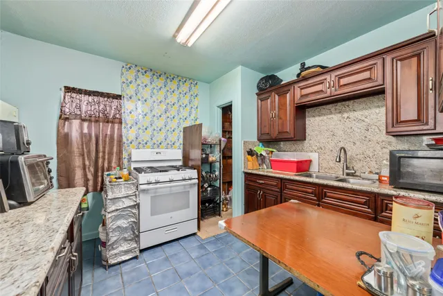 a kitchen with stainless steel appliances granite countertop a stove refrigerator sink and cabinets