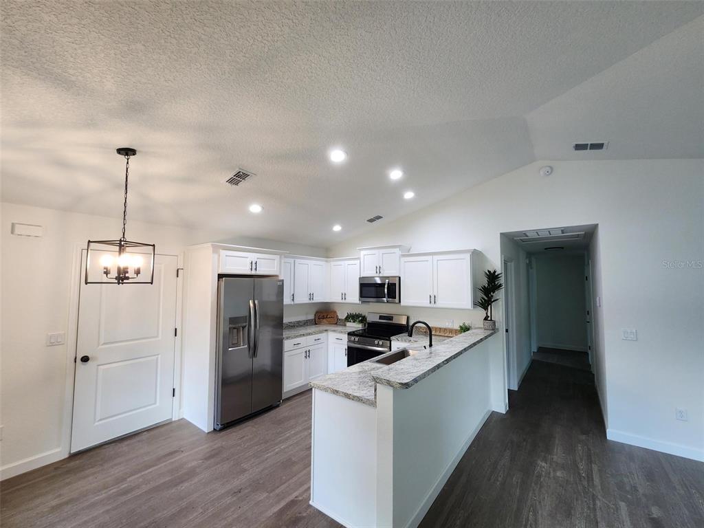 24370 Falcon Avenue Dunnellon, FL 34431 - Photo 24 of 24 a kitchen with stainless steel appliances kitchen island granite countertop a refrigerator a stove top oven a sink and dishwasher
