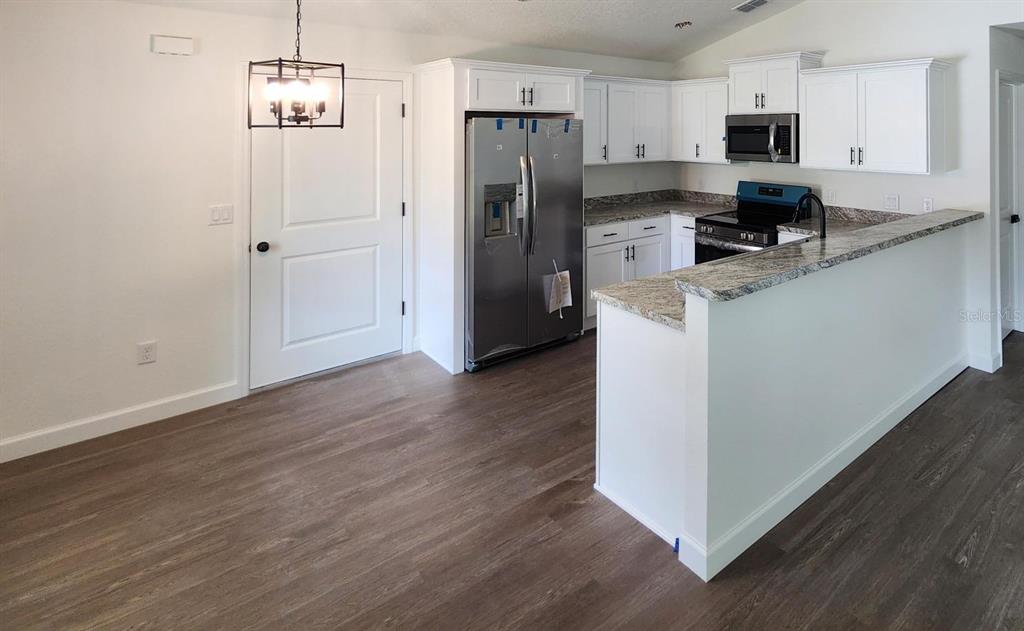 24370 Falcon Avenue Dunnellon, FL 34431 - Photo 4 of 24 a kitchen with stainless steel appliances a refrigerator and microwave