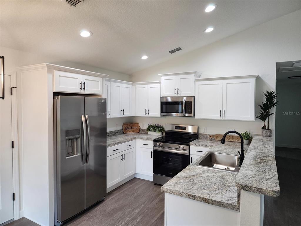 24370 Falcon Avenue Dunnellon, FL 34431 - Photo 5 of 24 a kitchen with stainless steel appliances granite countertop a sink stove refrigerator and cabinets