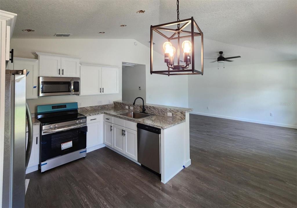 24370 Falcon Avenue Dunnellon, FL 34431 - Photo 6 of 24 a kitchen with stainless steel appliances granite countertop a stove a sink and a microwave