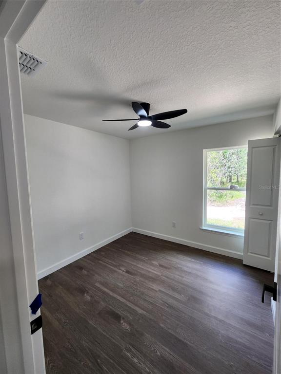 24370 Falcon Avenue Dunnellon, FL 34431 - Photo 10 of 24 a view of an empty room with a window and wooden floor