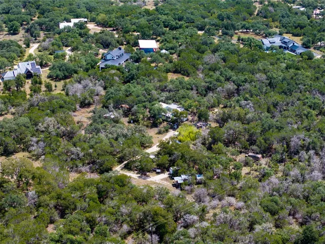 an aerial view of residential houses with outdoor space and trees