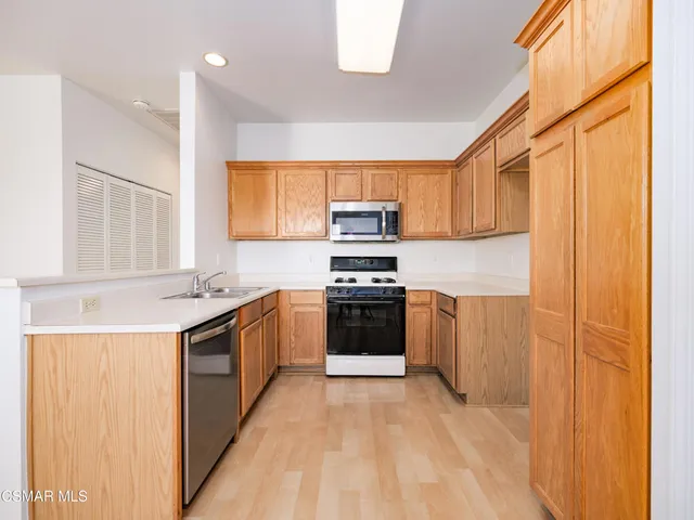 a kitchen with stainless steel appliances granite countertop a stove a sink and a refrigerator