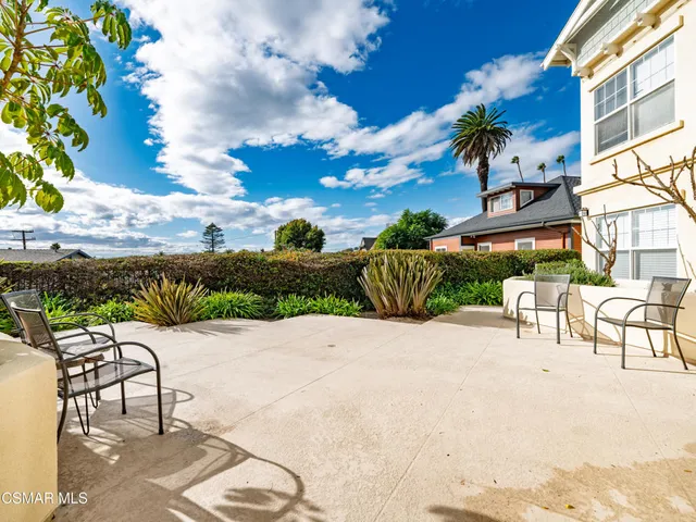 a view of a patio with a table and chairs under an umbrella