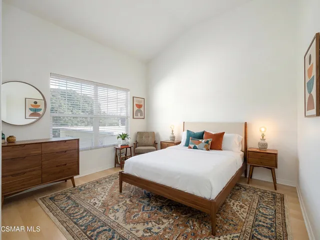 a bedroom with a bed a dresser and chair