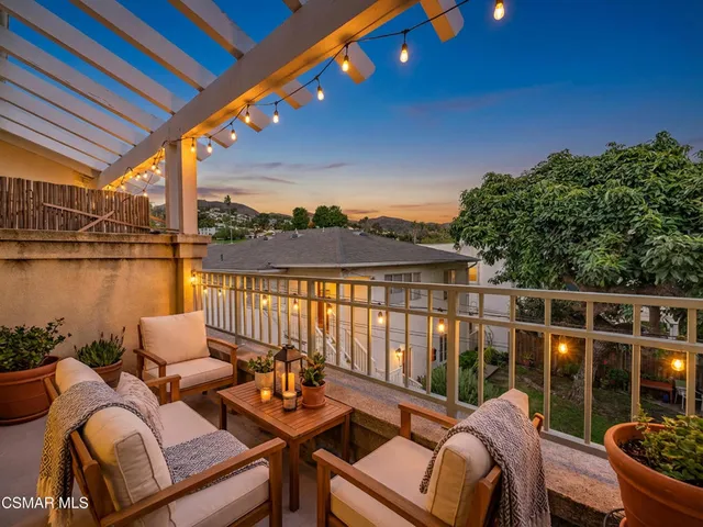 a roof deck with couches and wooden floor