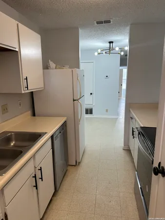 a kitchen with a refrigerator and a sink