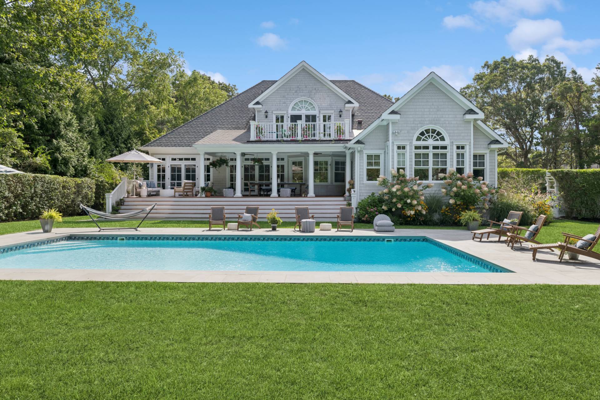 a front view of a house with swimming pool and porch