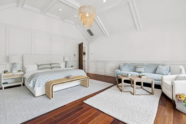 a bedroom with a bed wooden floor and table