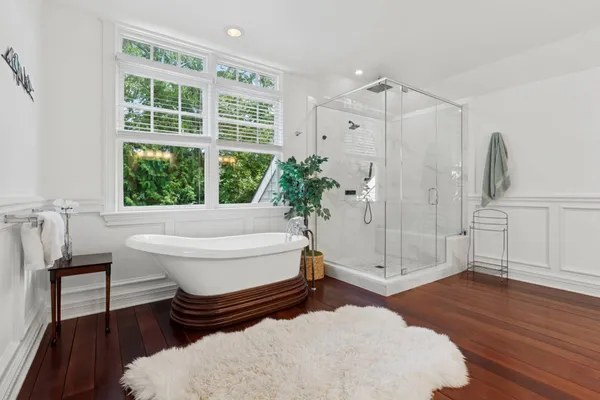 a bathroom with a tub shower and window