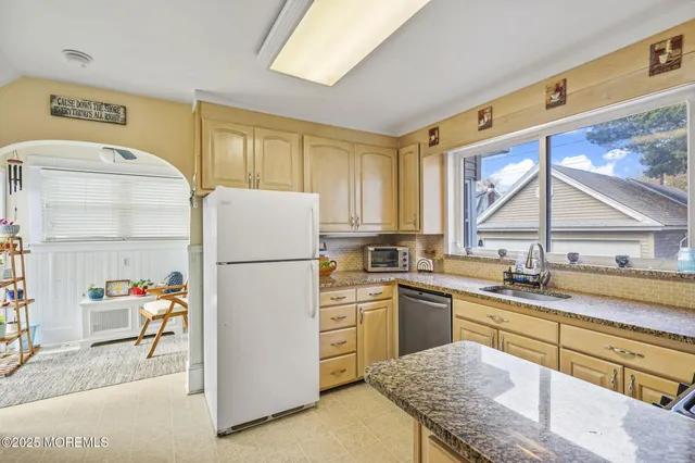 a kitchen with a sink a refrigerator and window