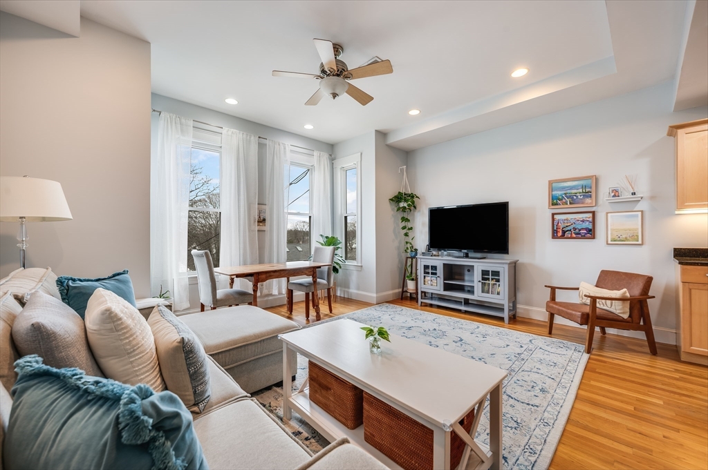 a living room with furniture a flat screen tv and a large window