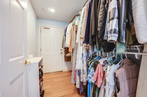 a view of walk in closet with clothes and shoes