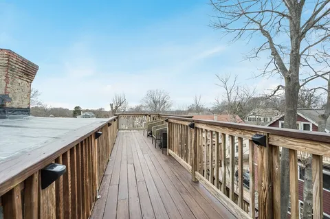 a view of roof deck with wooden fence and floor