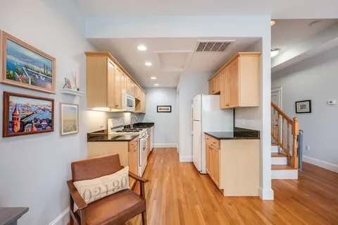 a kitchen with stainless steel appliances kitchen island granite countertop a stove a sink and a refrigerator