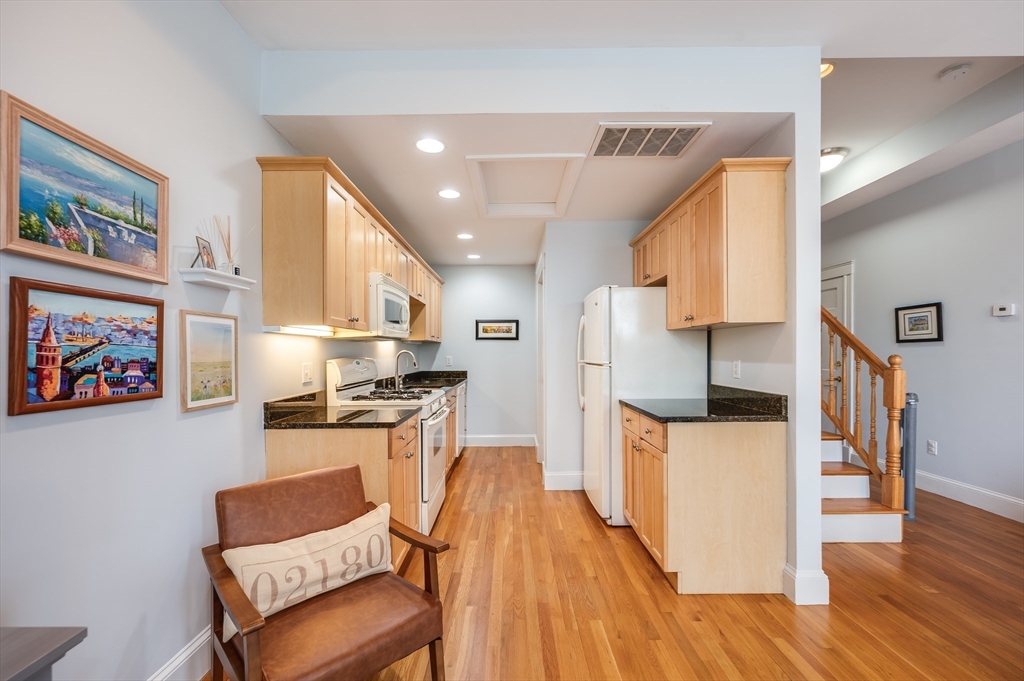 39 Chestnut Street, Unit 2C Stoneham, MA 02180 - Photo 5 of 21 a kitchen with stainless steel appliances kitchen island granite countertop a stove a sink and a refrigerator
