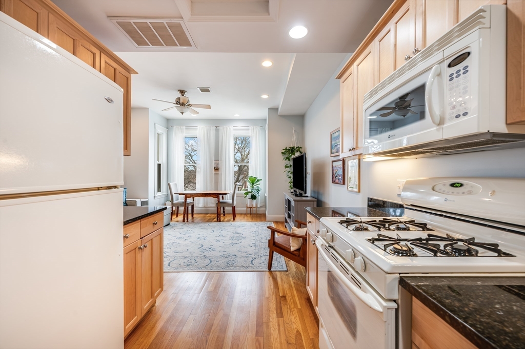 39 Chestnut Street, Unit 2C Stoneham, MA 02180 - Photo 7 of 21 a kitchen that has a stove and a wooden floor